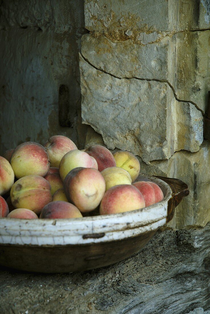 Peaches in a dish on a wall