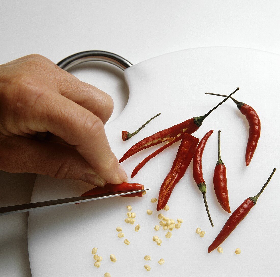 Scraping the seeds out of chili peppers