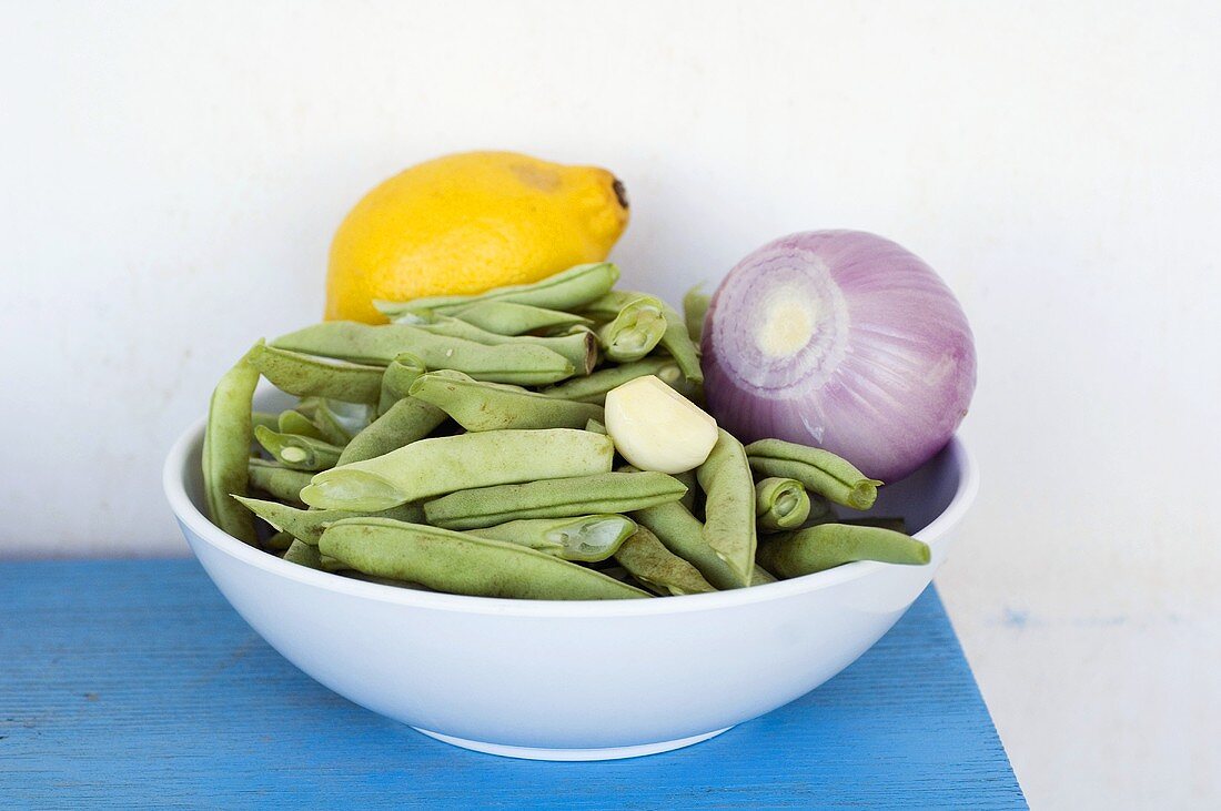Green beans, red onion and lemon in bowl