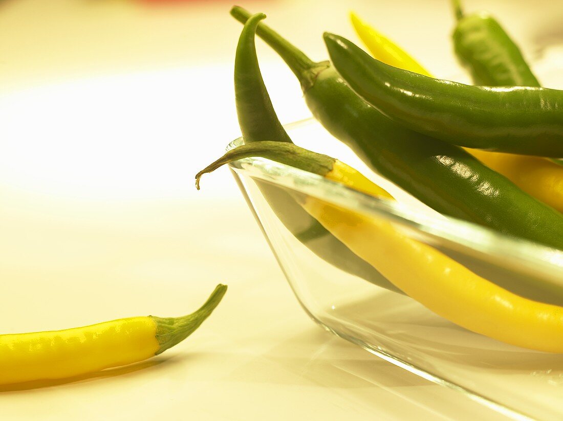 Yellow and green chillies in glass dish