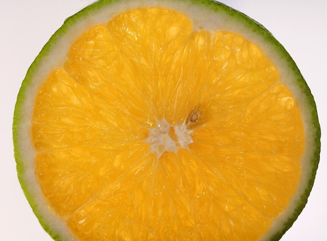 Eine Orangenscheibe mit grüner Schale