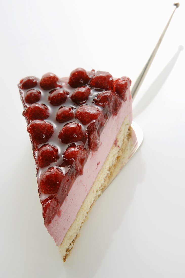 A piece of raspberry cake on cake server