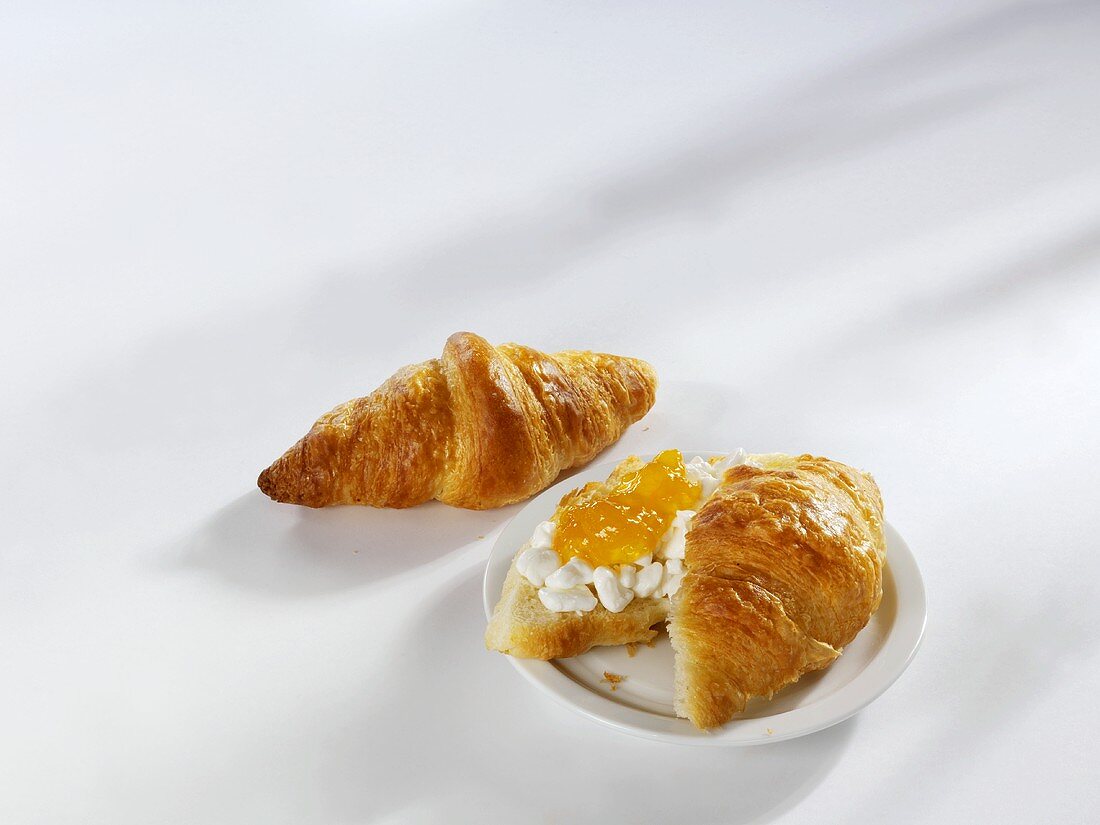 Zwei Croissants, eins mit Hüttenkäse und Marmelade