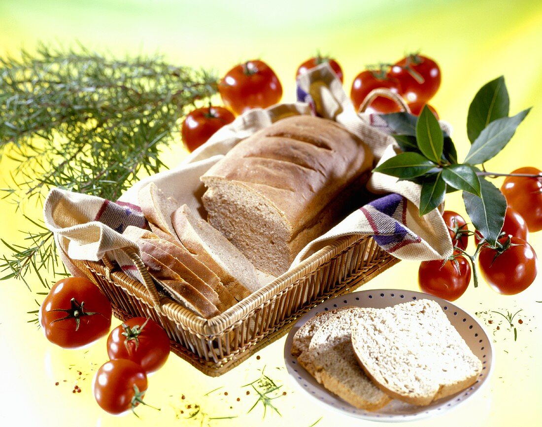 Still life with white tin loaf, tomatoes and herbs