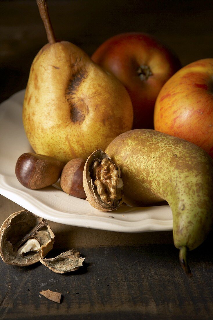 Obstteller mit Äpfeln, Birnen und Nüssen