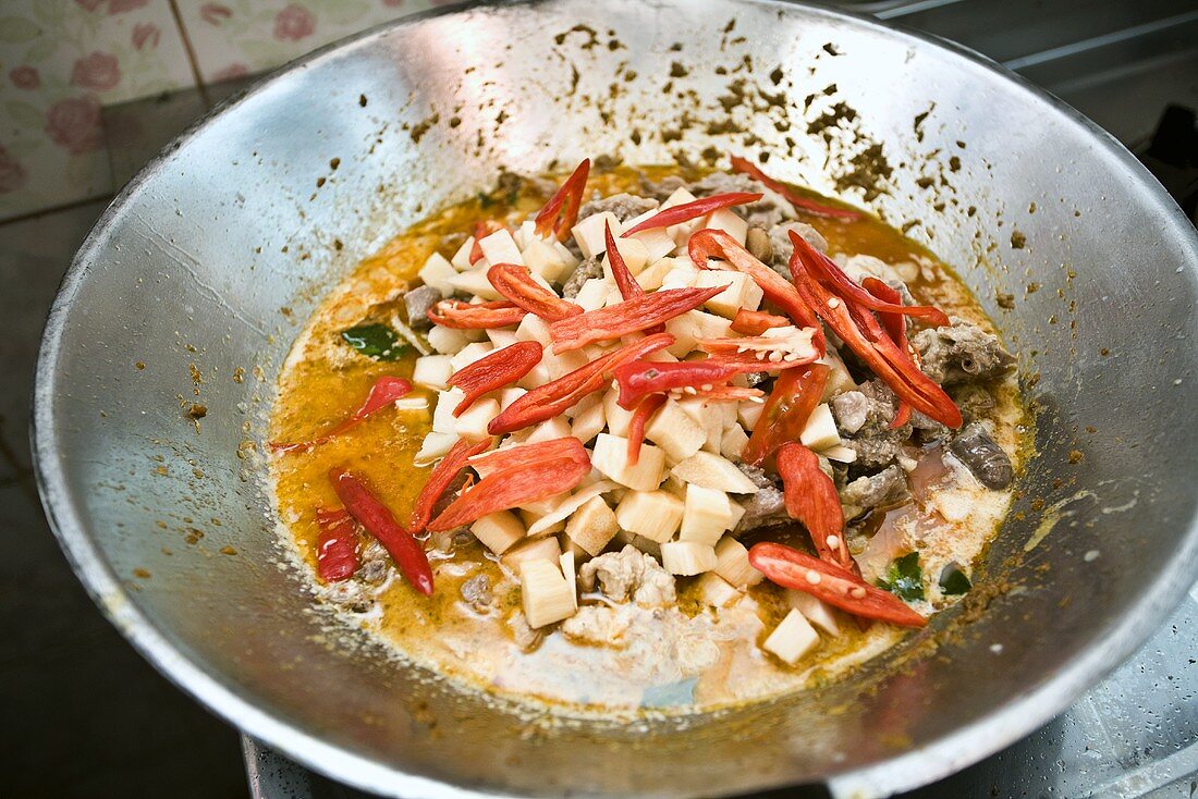 Making green chicken curry with red chillies