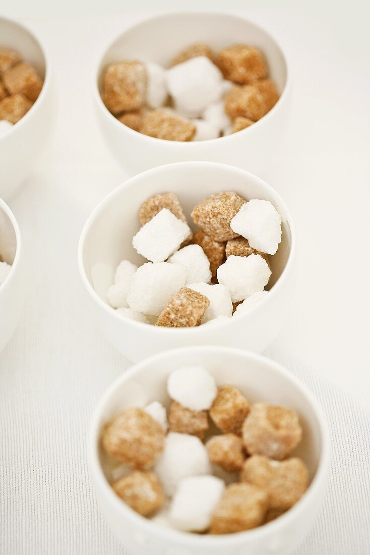 Brown and white sugar cubes in small bowls