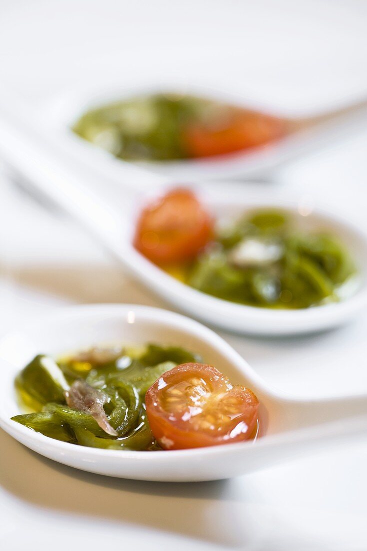 Cocktail tomatoes with anchovies and green pepper in spoons