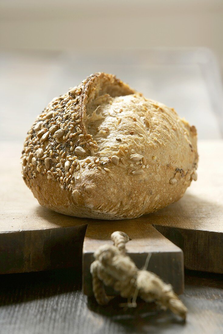 A loaf of wholemeal bread on a wooden board