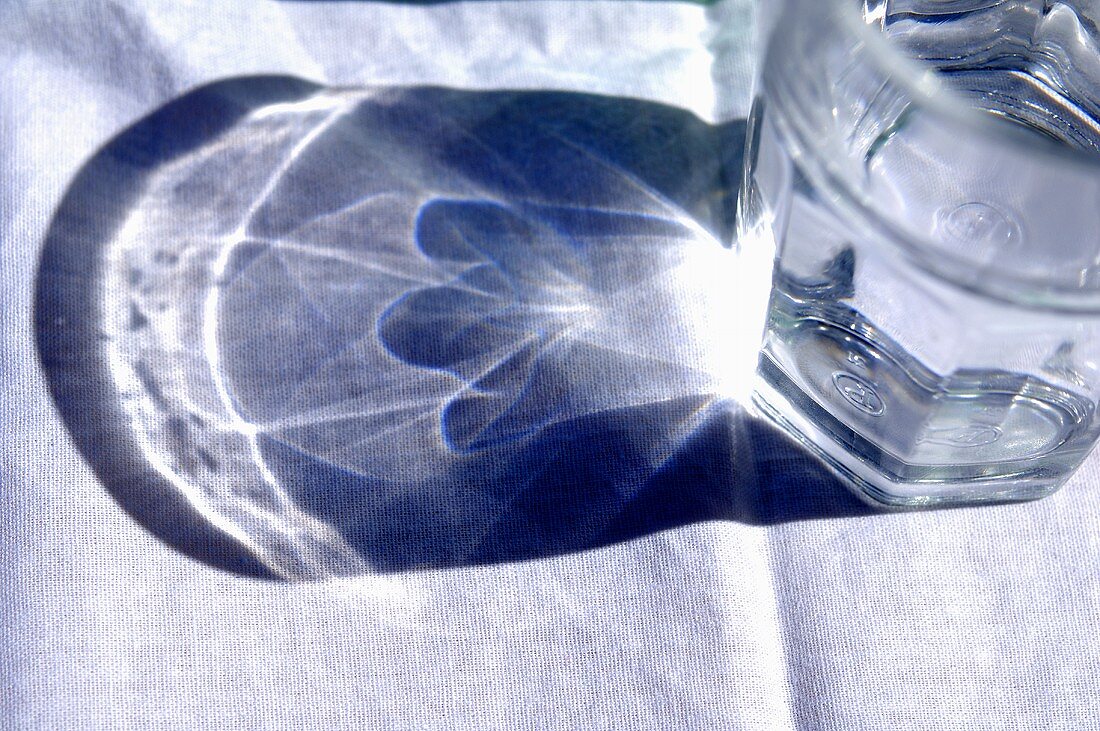 Wasserglas mit Schatten auf dem Tisch