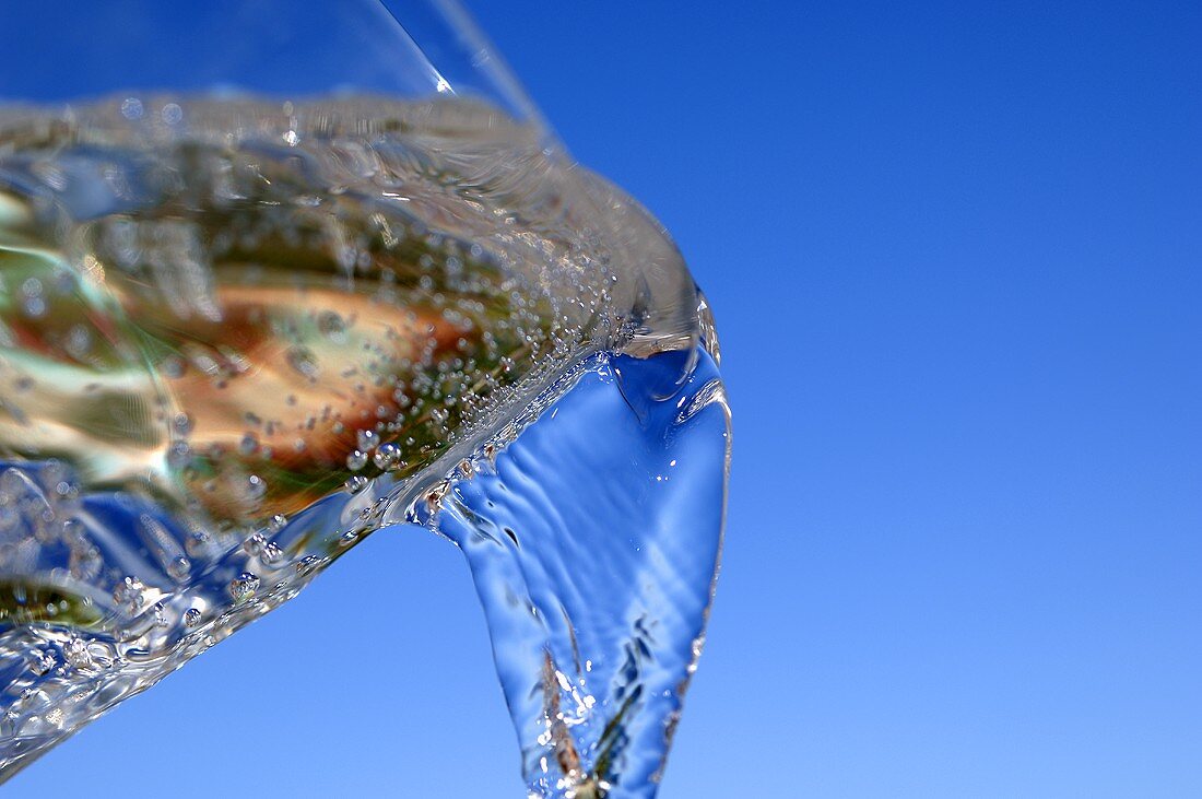 Wasser aus einem Glas gießen