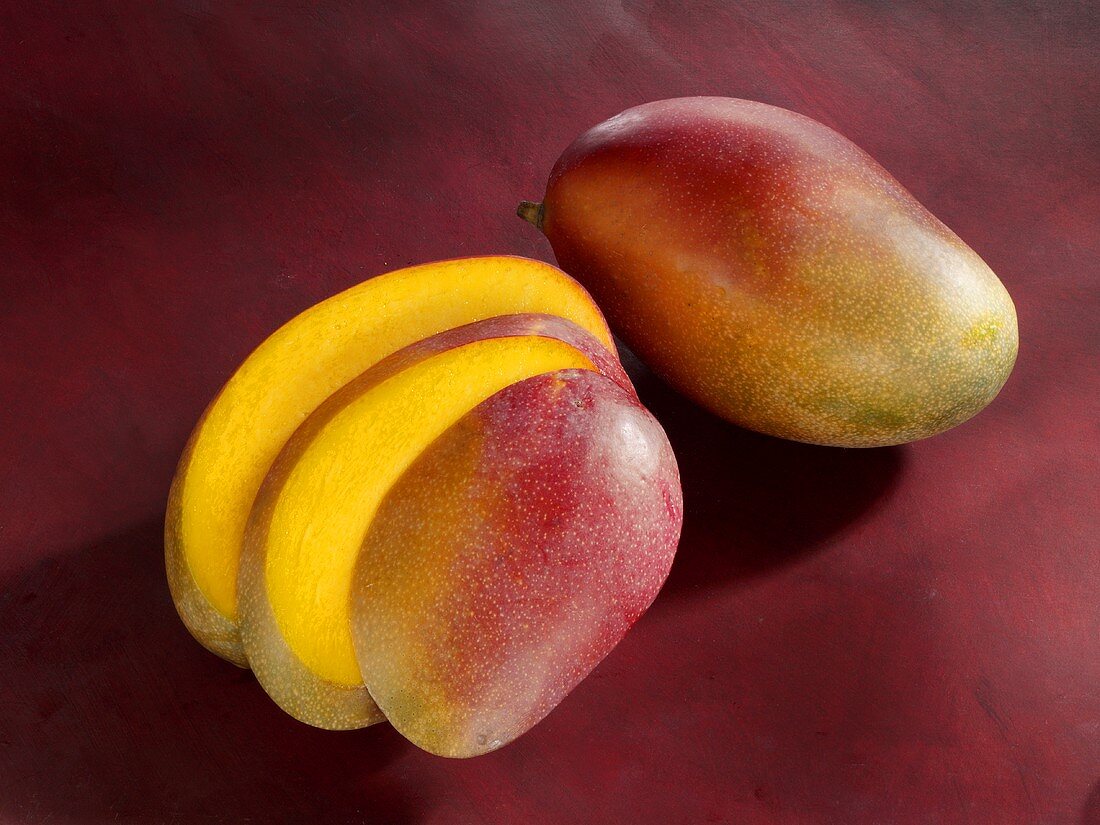 Eine ganze Mango und eine Mango in Scheiben