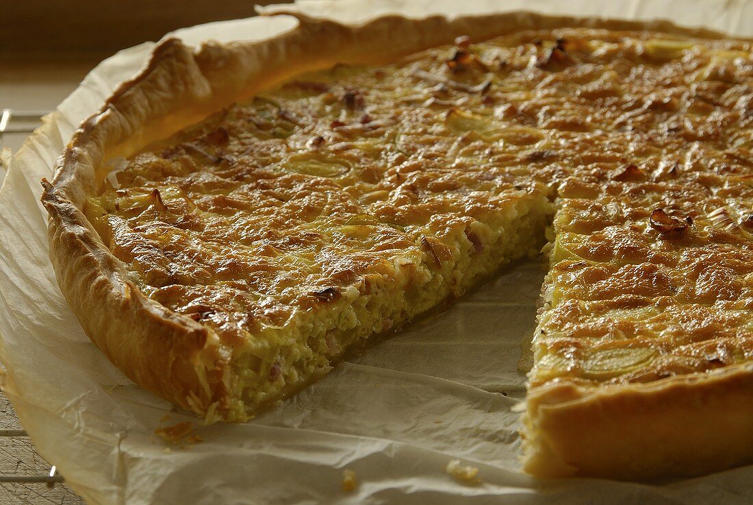 Eine angeschnittene Zwiebelquiche auf Backpapier