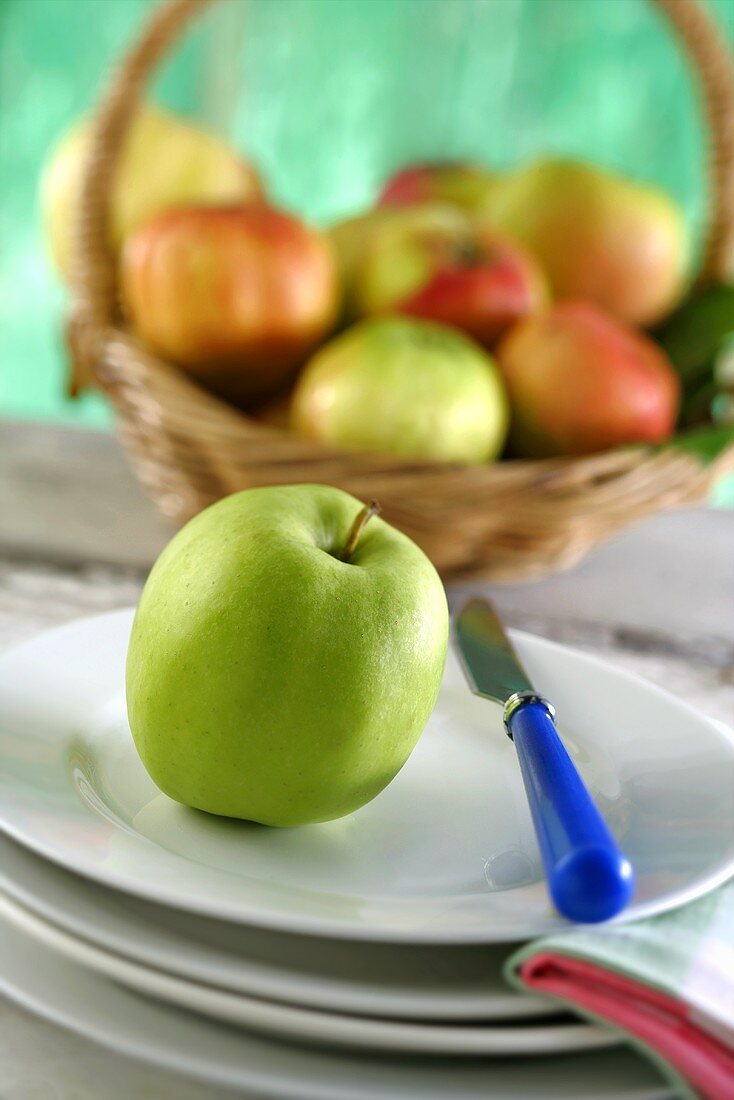 Apfel auf Teller vor Obstkorb