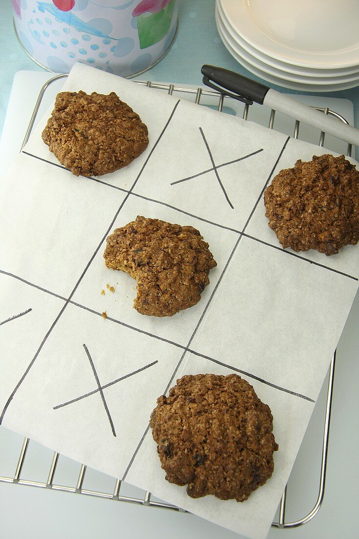 Oat cookies on a pieces of paper (noughts and crosses)