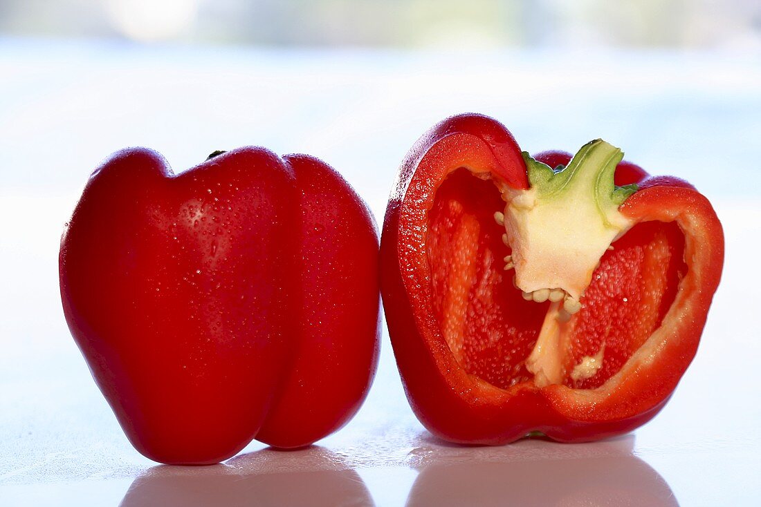 A whole and a halved red pepper
