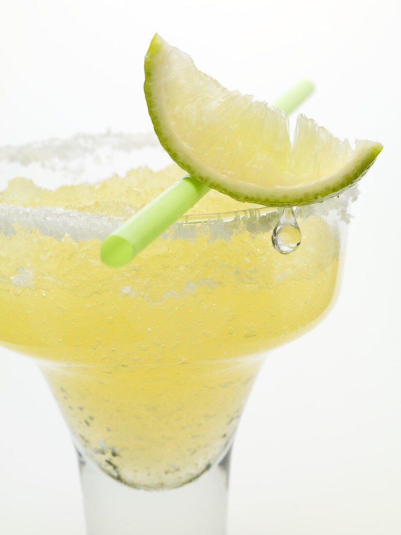 Frozen Margarita with lime wedge and straw