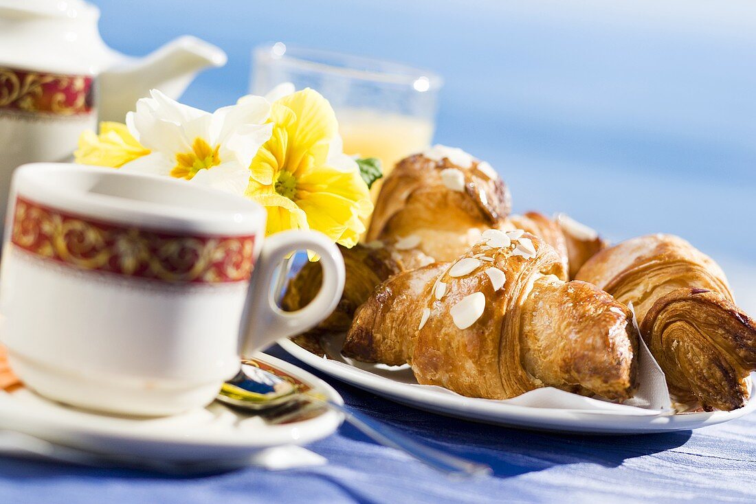 Frühstück mit Tee und drei Mandelcroissants