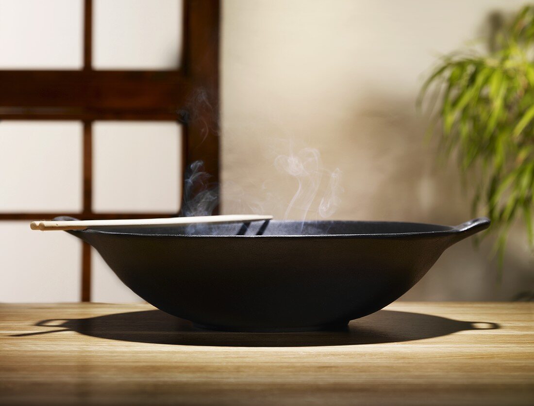 Steaming wok on wooden table