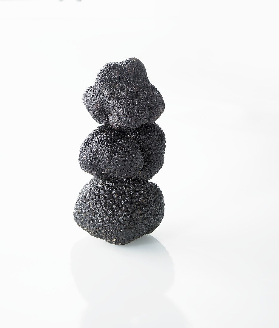 Three black truffles, stacked