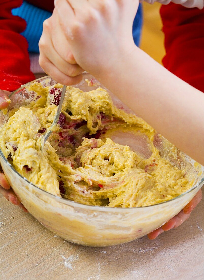 Child stirring muffin mixture