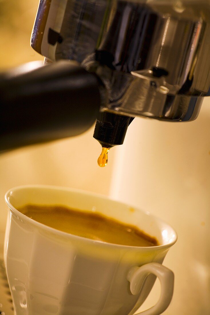 Espresso dripping into a cup