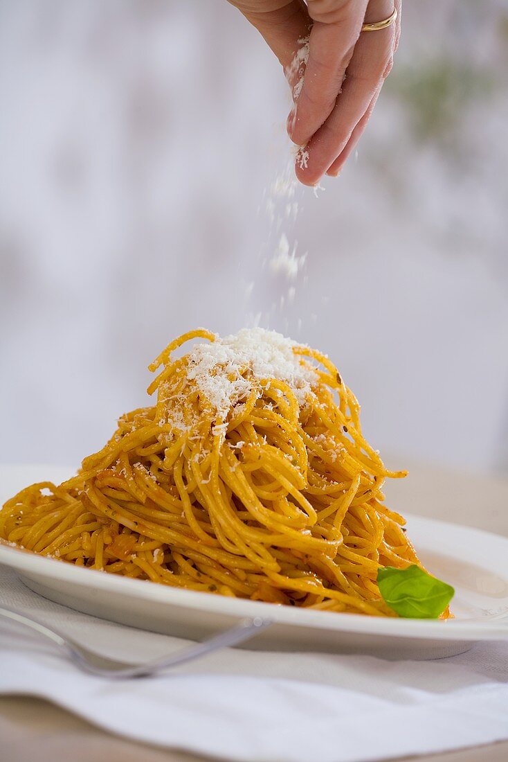 Spaghetti Bolognese mit Parmesan bestreuen