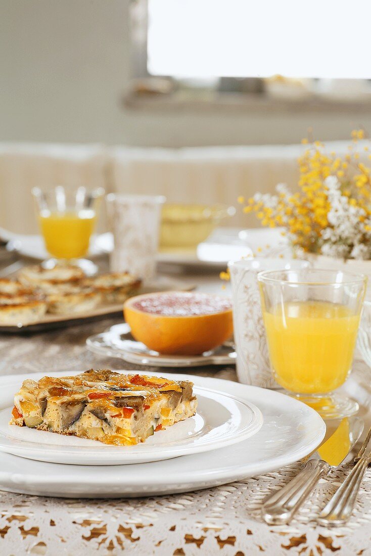 Gedeckter Tisch mit Gemüse-Frittata und Obstsaft zum Brunch