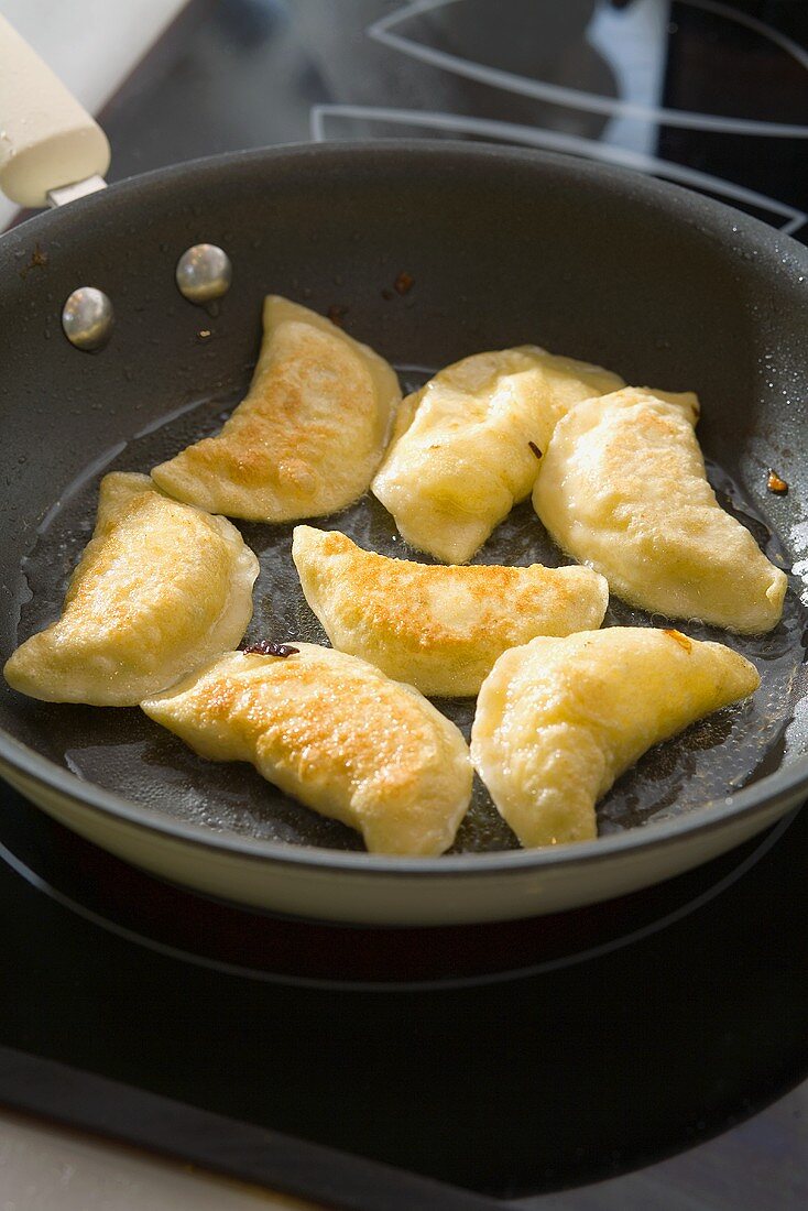 Frying pierogi in a frying pan