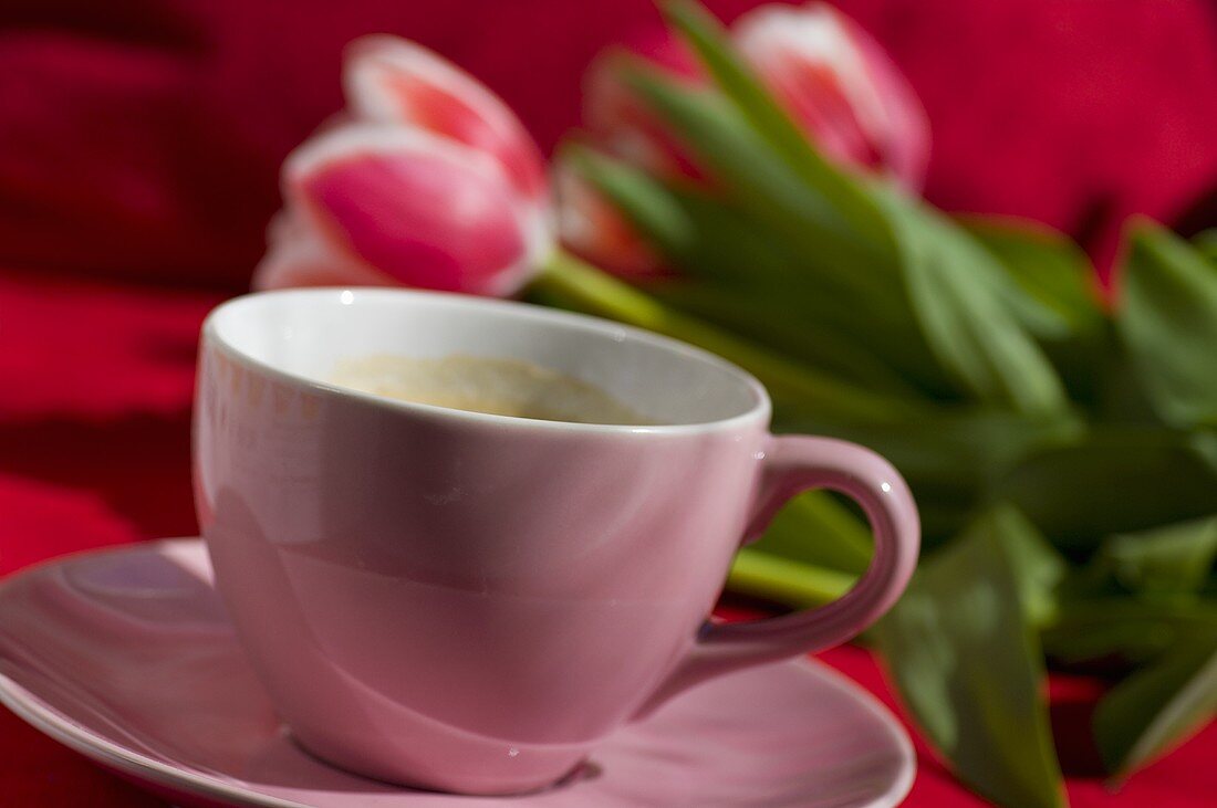 A cup of coffee with tulips