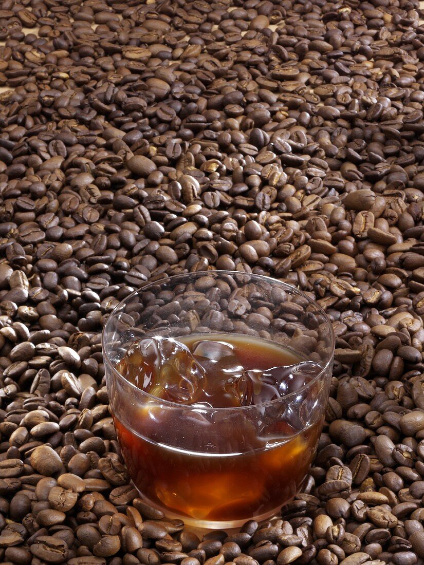 Glass of mazagran (coffee drink) on coffee beans
