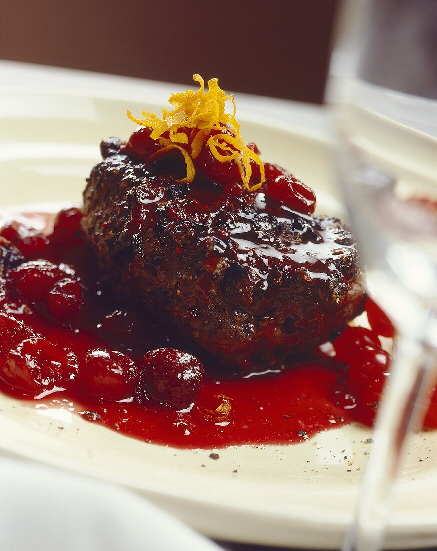 Grilled venison steak with cherry sauce