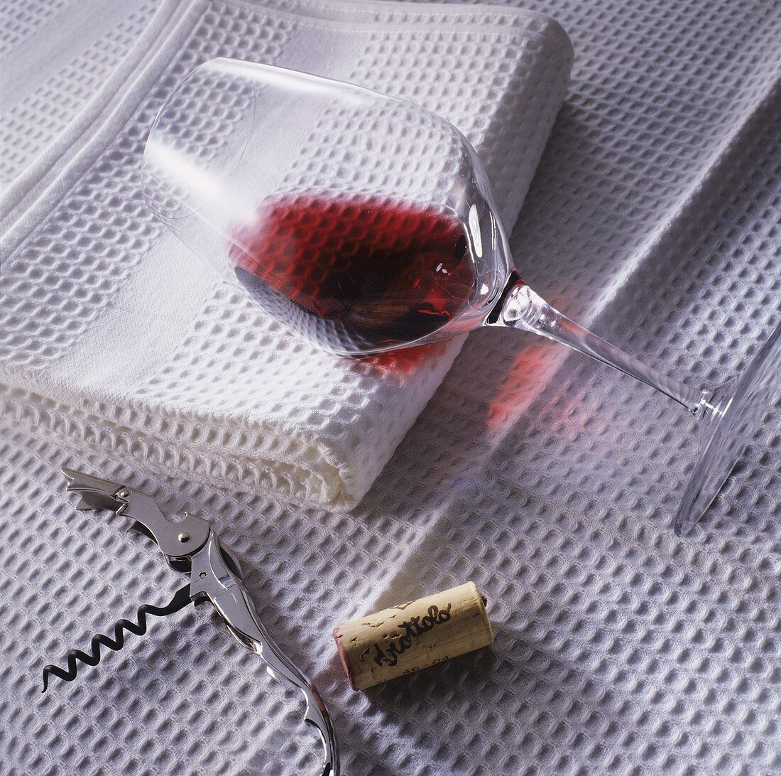 Glas mit Rotwein auf weißem Tuch