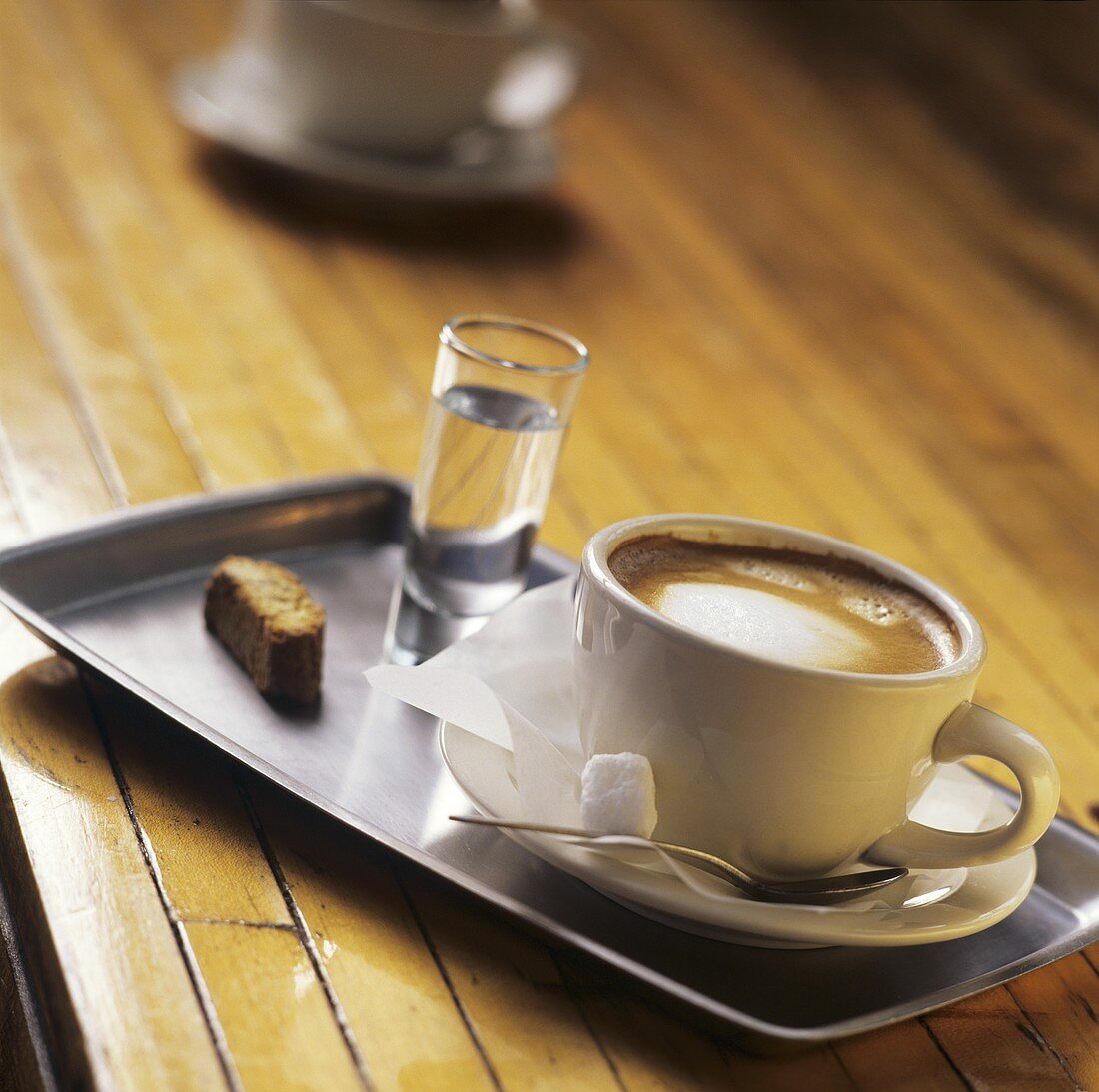 Cappuccino and grappa on tray