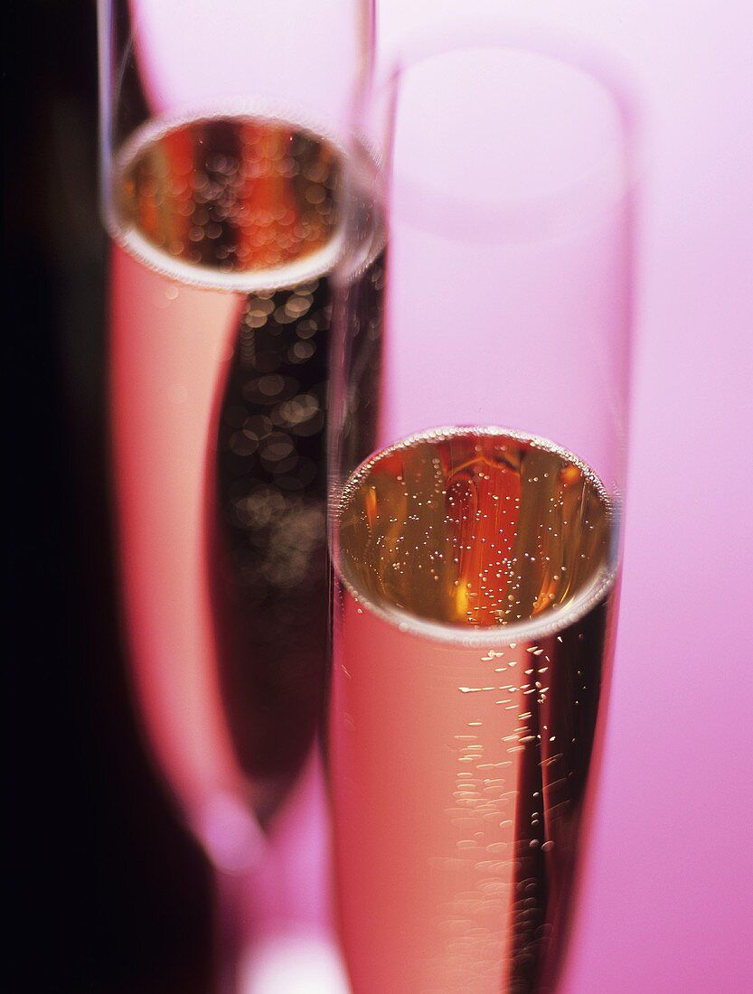 Zwei Gläser rosefarbener Champagner