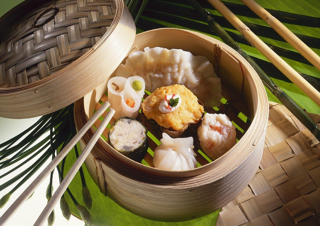 Dim Sum or Chinese dumpling in a stream hot pot of food wheelbarrow on  street food of Bangkok. Many dumpling in a wooden basket is streaming in  old As Stock Photo 