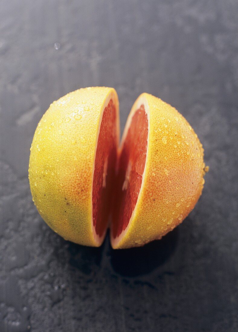A pink grapefruit, cut in half