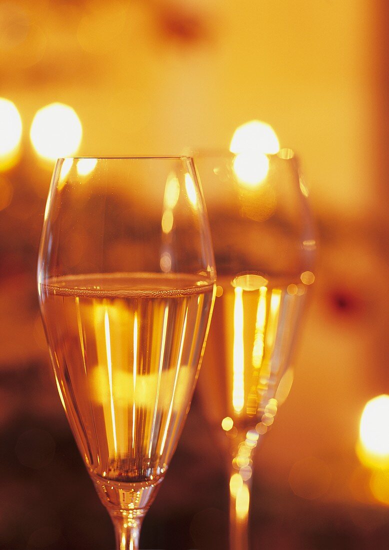 Two glasses of sparkling wine in subdued light