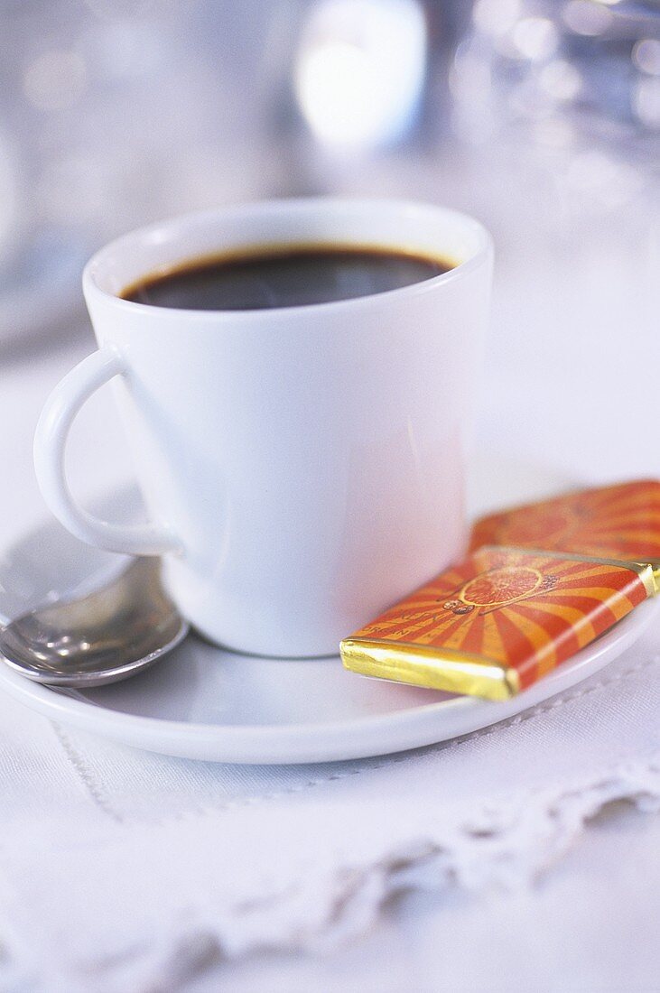 Cup of coffee with chocolate thins in saucer