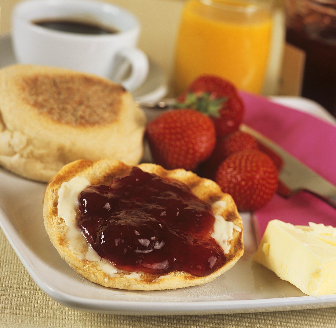 English muffin with butter and strawberry jam