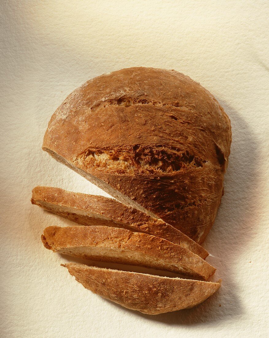 A loaf of bread, partly sliced