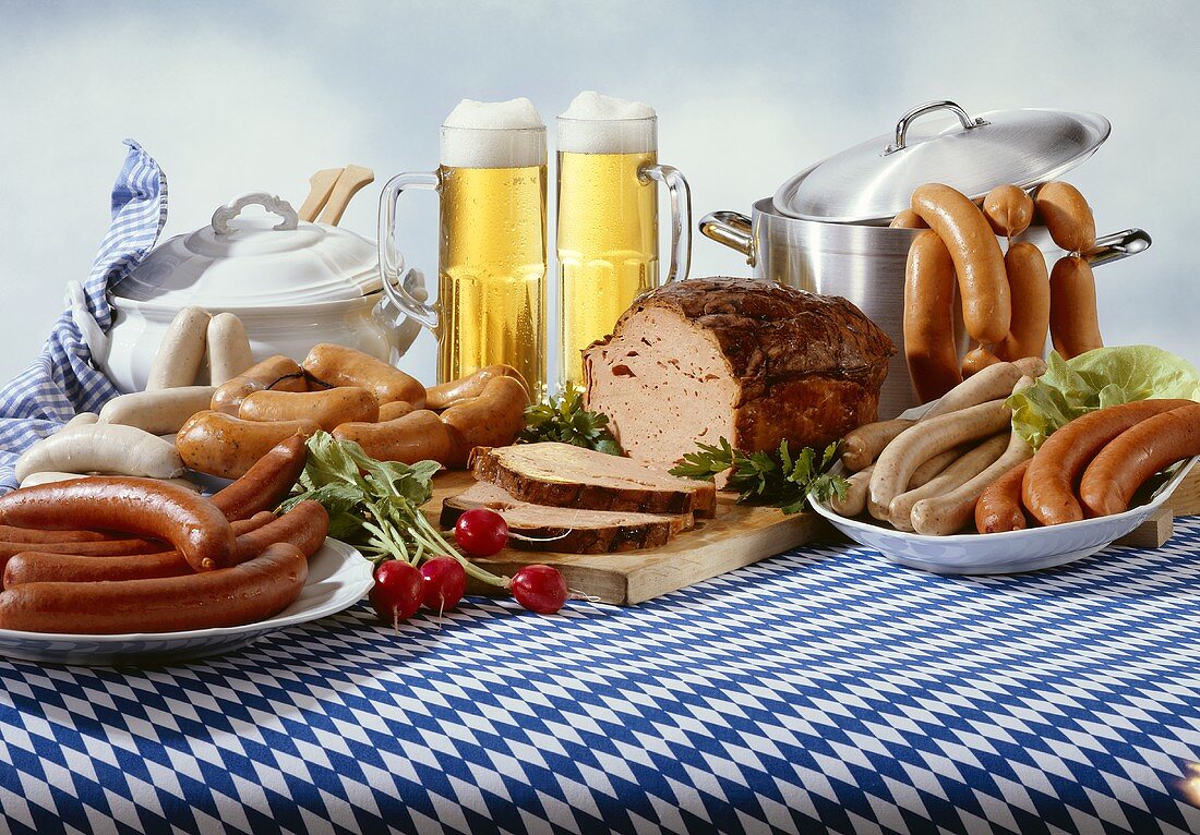 Bayerische Wurstspezialitäten mit Bier auf Tischdecke