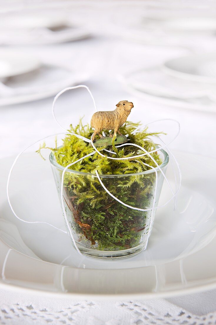 Glass of moss with Easter lamb on plate