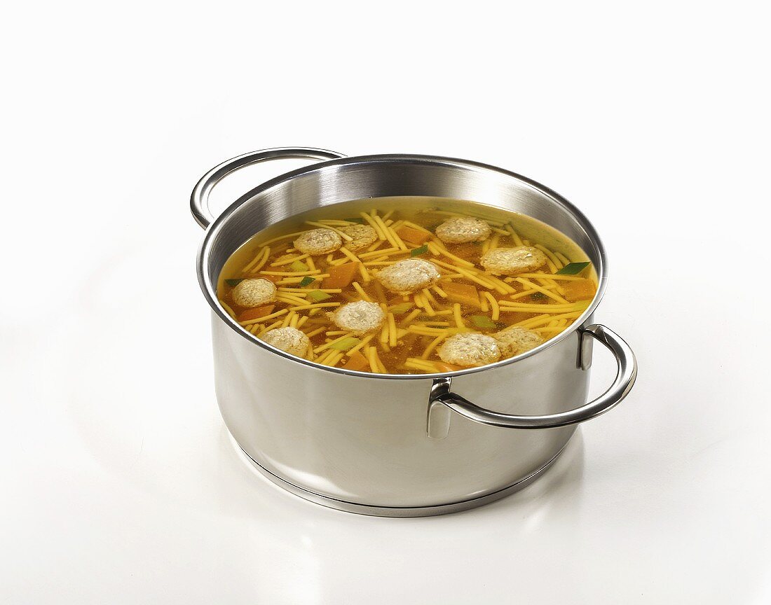 Clear broth with noodles and dumplings in pan
