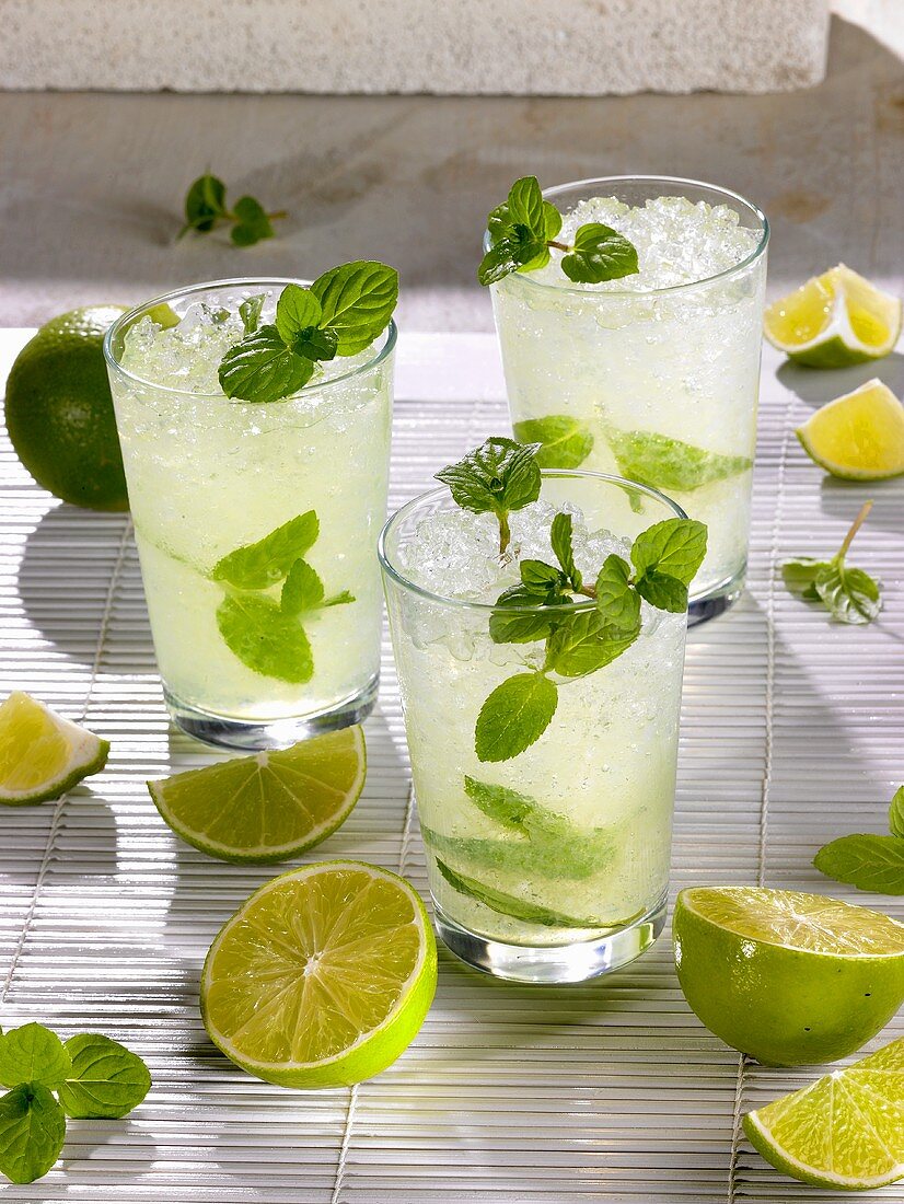 Drei Mojitos mit Limetten und Minze