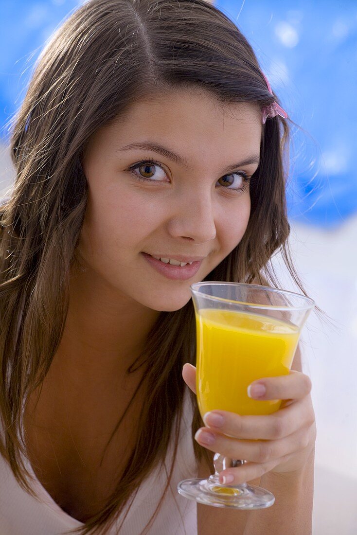 Mädchen hält Glas Orangensaft