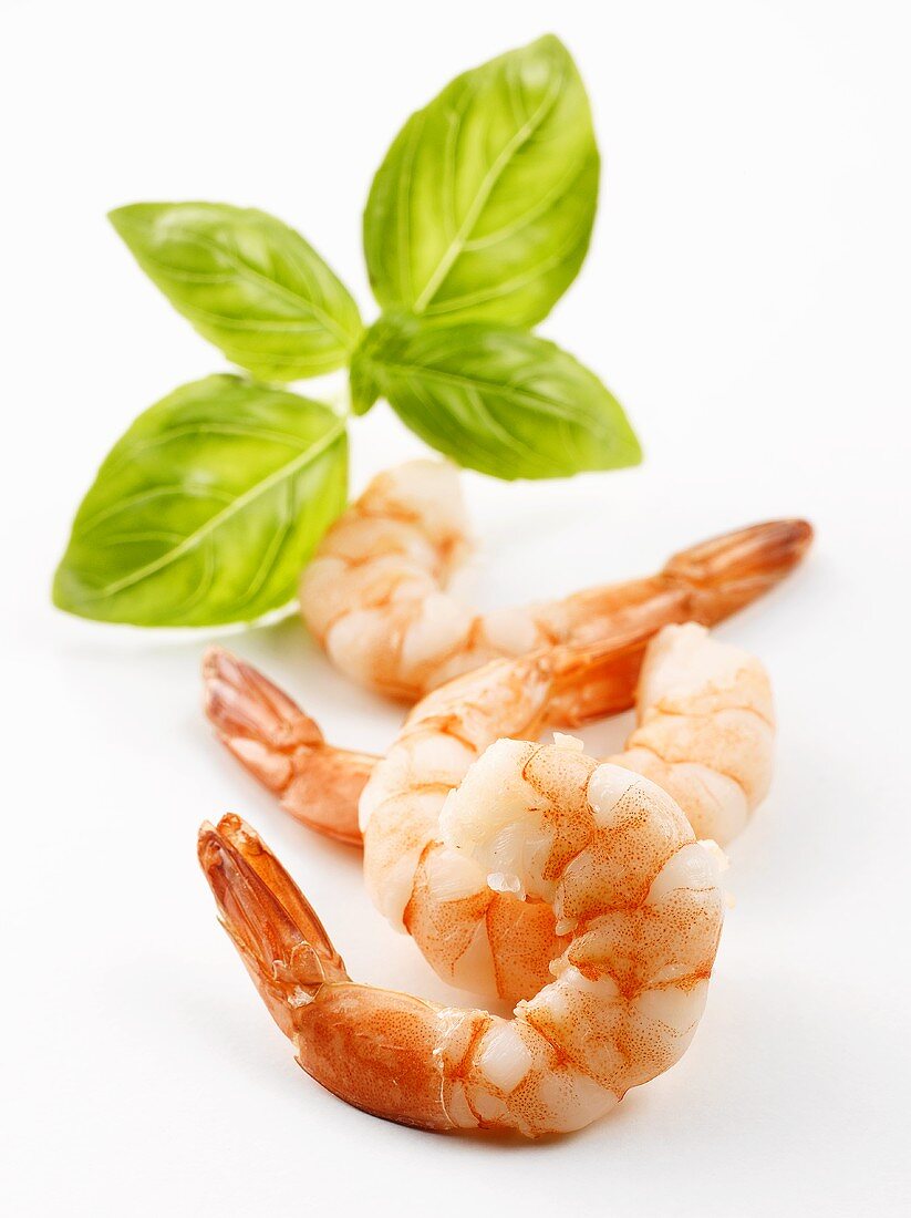 Four peeled prawns with basil