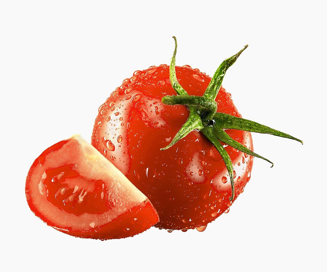 Ganze Tomate und Tomatenviertel mit Wassertropfen