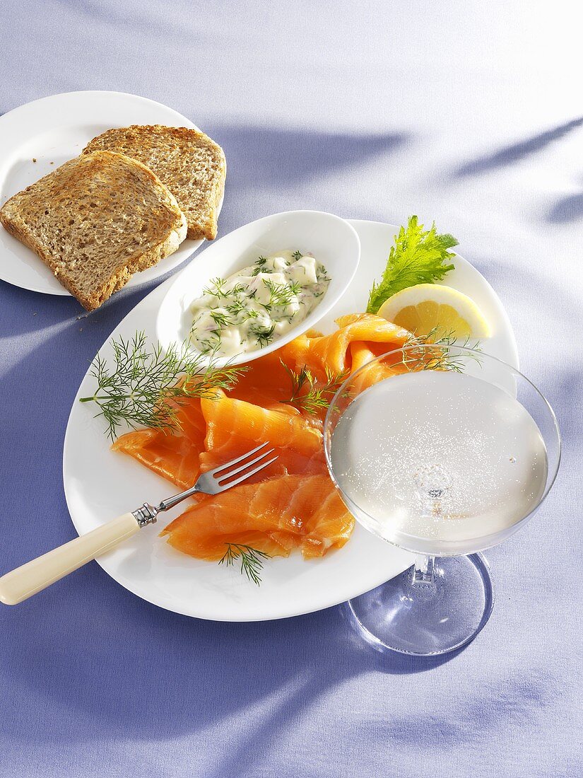Smopked salmon with a lemon and dill sauce, toast and champagne