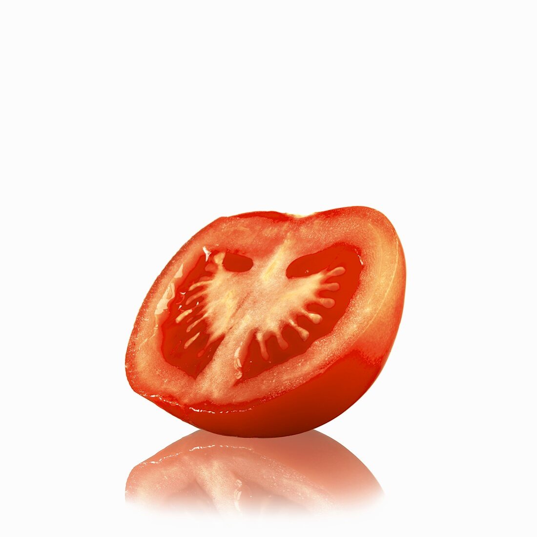 Halbe Tomate auf weißem Untergrund mit Spiegelung